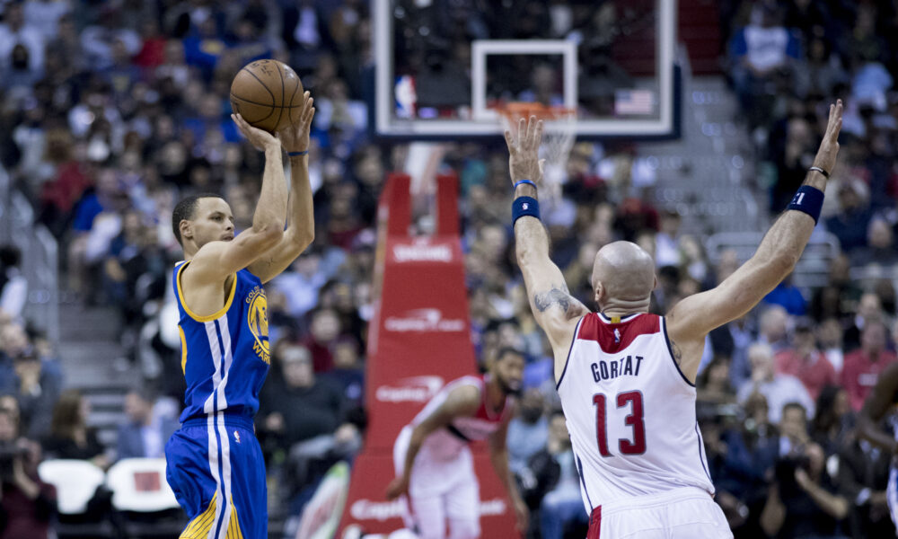 Stephen Curry shooting toward the basket against a defender