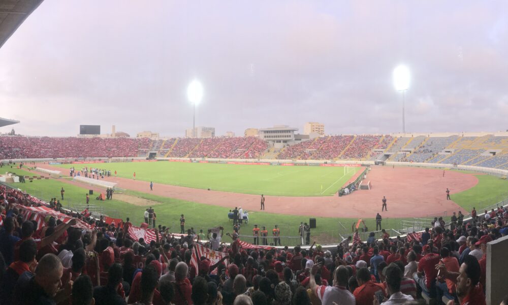 Soccer stadium with pitch and stands during a match