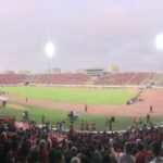 Soccer stadium with pitch and stands during a match