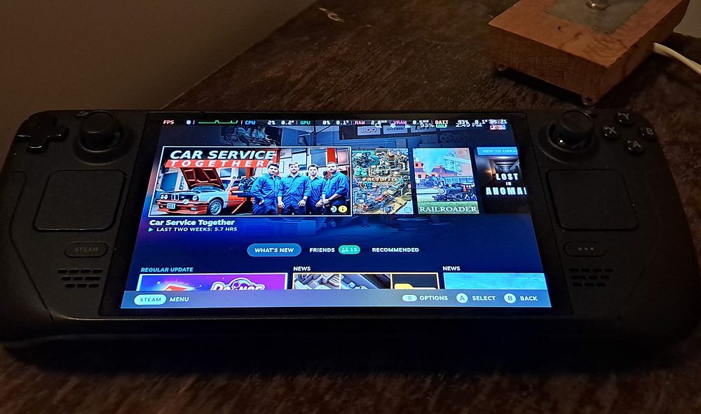 Steam Deck OLED handheld gaming PC resting on a wooden table with its home screen visible