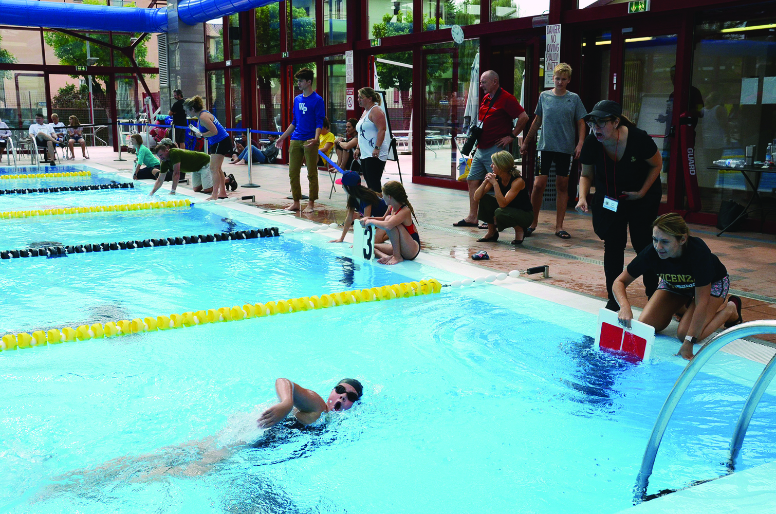 Swimmer being supported near a pool wall during a youth swim meet in Vicenza, Italy, in 2018