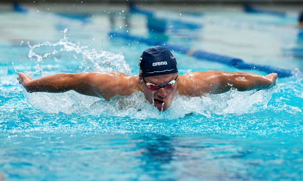 Air Force Academy swimmer demonstrates butterfly stroke with both arms out over the water