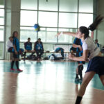 Team handball players during an indoor handball match, illustrating passing and court play
