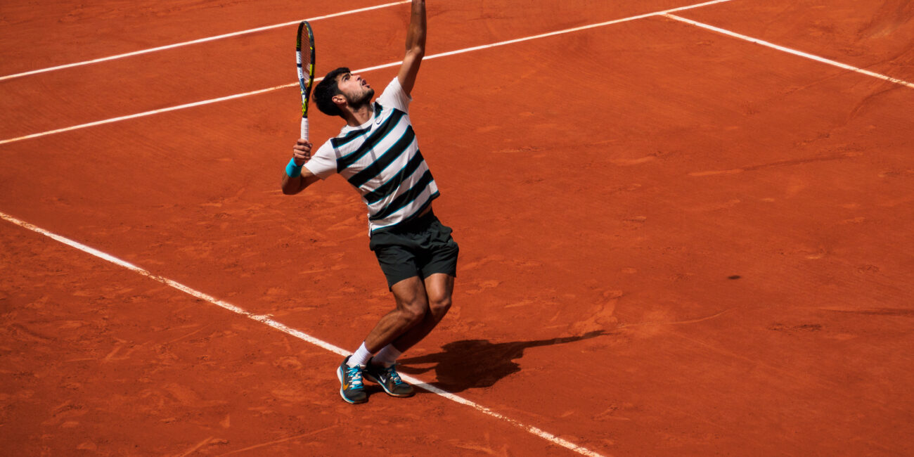 Carlos Alcaraz serving a tennis ball at Roland Garros, illustrating how an ace begins