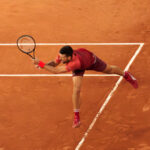 Novak Djokovic returning a tennis serve with his backhand at the 2024 French Open