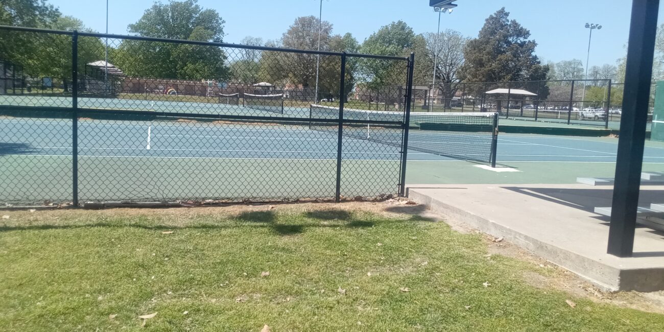 Outdoor tennis courts showing singles and doubles boundary lines and nets