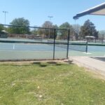 Outdoor tennis courts showing singles and doubles boundary lines and nets