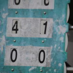 Manual tennis scoreboard showing game scores on a tennis court