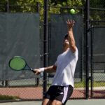 Real tennis player serving a ball in a match