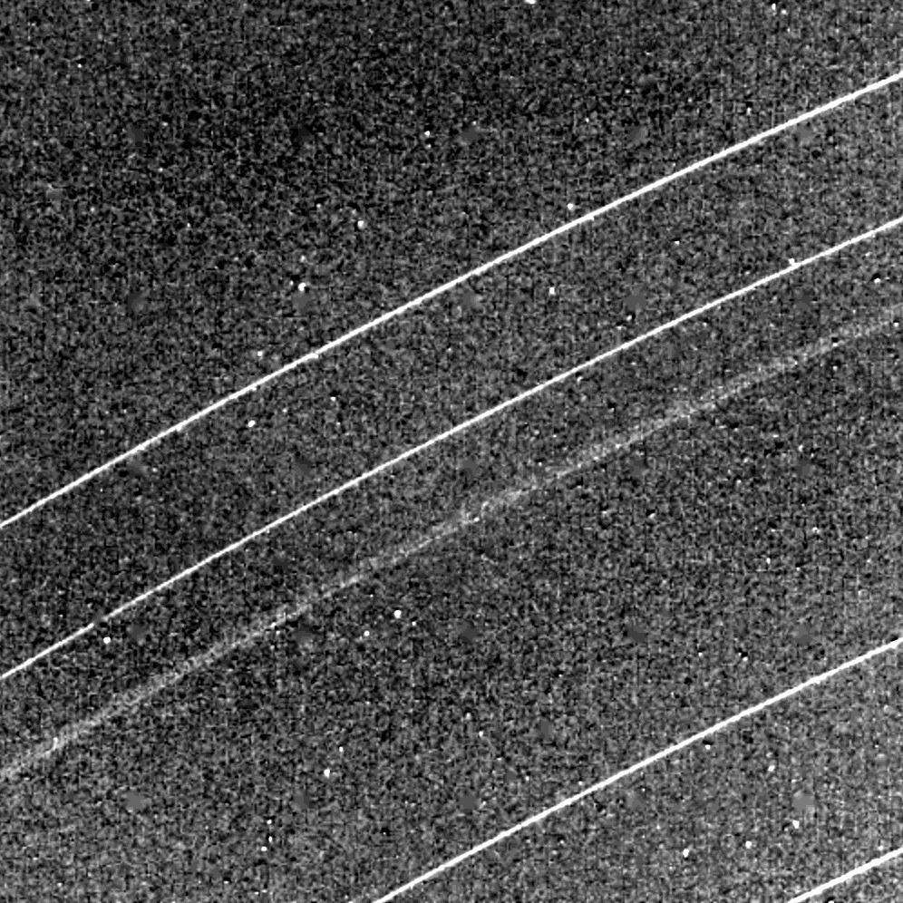 Actual NASA Voyager 2 1986 image of Uranus's rings made from the spacecraft during its flyby, showing arcs of faint narrow ring particles against black space