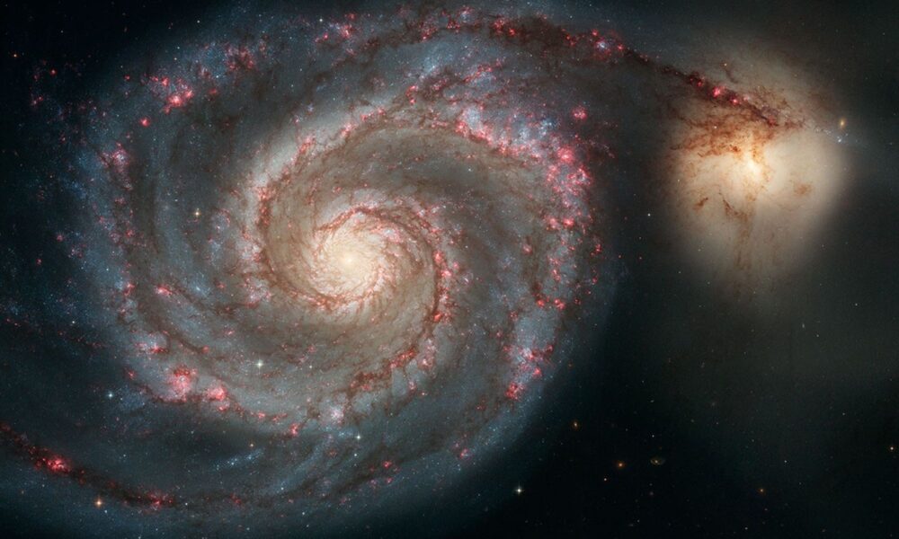 Actual 2005 Hubble photo of Whirlpool Galaxy M51 seen face on with two dusty spiral arms, pink star forming regions and interacting companion NGC 5195