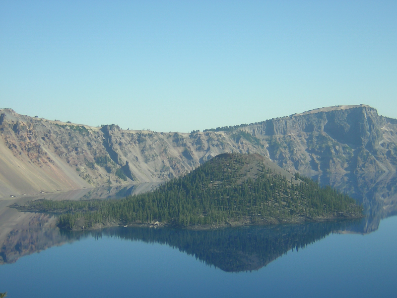 Real photograph of Wizard Island's tree-covered volcanic cinder cone surrounded by Crater Lake, Oregon