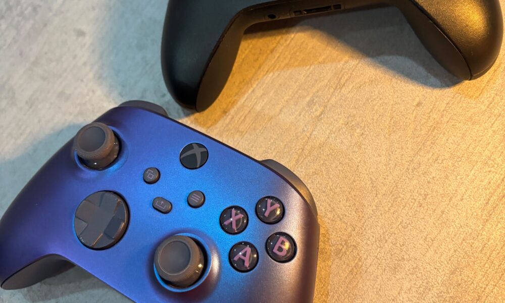 Real photograph of two physical Xbox wireless controllers on a desk