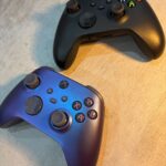 Real photograph of two physical Xbox wireless controllers on a desk