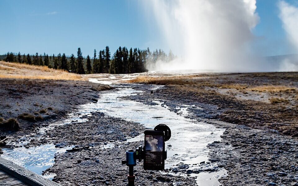 Smartphone on a tripod broadcasting an eruption of Old Faithful in Yellowstone National Park