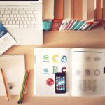 Laptop, books and stationery on a desk representing college application planning