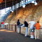 Visitors examining the Wall of Bones inside Dinosaur National Monument's Quarry Exhibit Hall in Utah