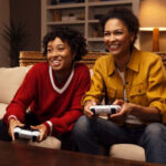 Two players using PlayStation DualSense controllers for local Fortnite split-screen play on PS5