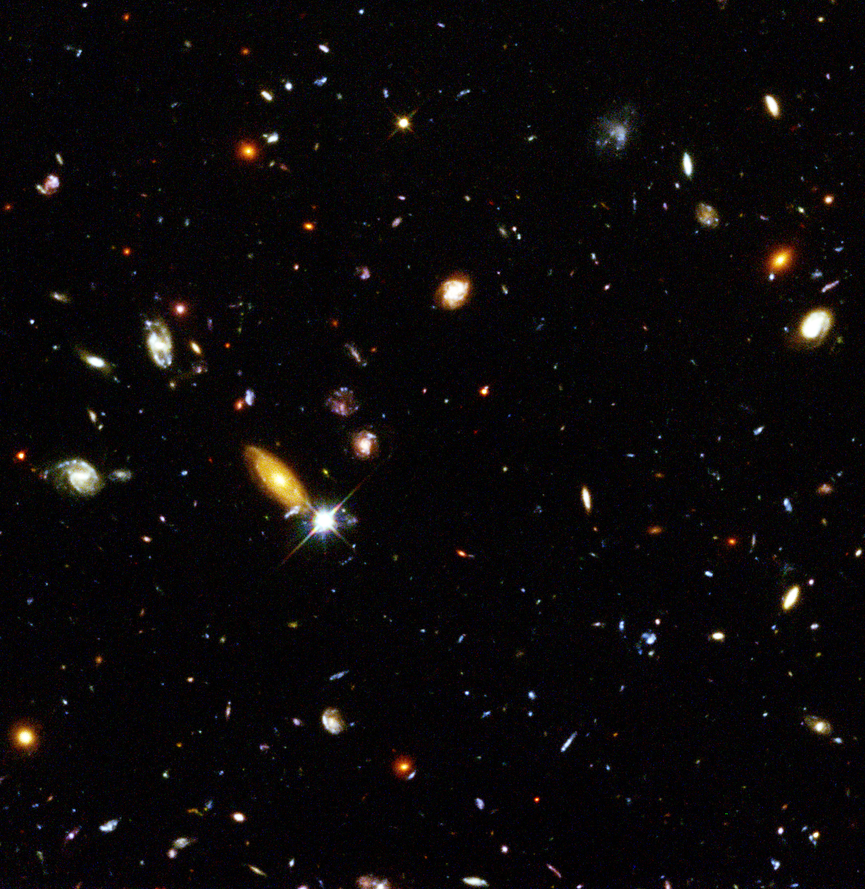 Original 1995 Hubble Deep Field observation, a dense field of real distant galaxies in different colors and shapes on a dark sky