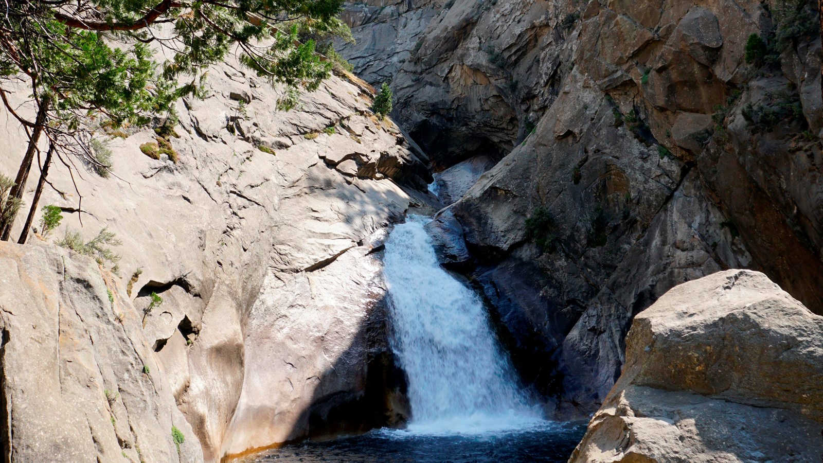 Actual National Park Service photograph of Roaring River Falls in Kings Canyon National Park pouring through granite rock walls into a dark pool