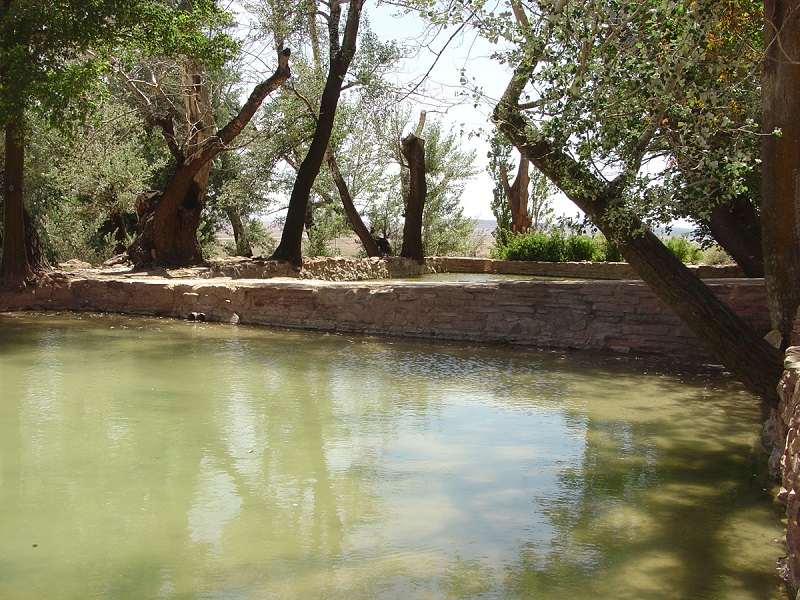 Stone-lined pond and trees beside Winsor Castle at Pipe Spring National Monument