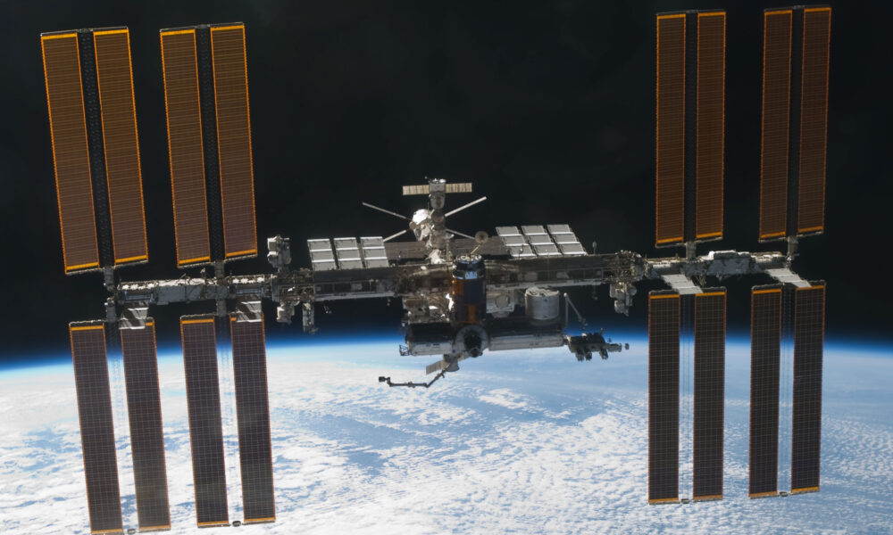 Authentic NASA photograph of the International Space Station in orbit above Earth's clouds, March 7 2011, STS-133 Discovery fly-around