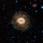 Real NASA Spitzer Space Telescope infrared observation of the Ring Nebula Messier 57 (NGC 6720) showing a diffuse flower-like outer shell around a glowing central ring