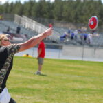 Real U.S. Army photograph of veteran Chanda Gaeth throwing a discus from a seated position during the 2013 Warrior Games