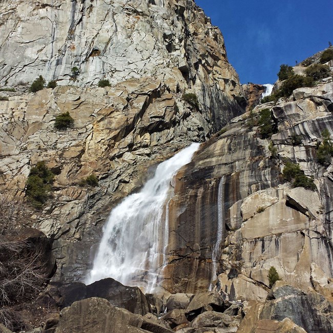 Actual National Park Service photograph of Wapama Falls cascading over granite cliffs at Hetch Hetchy in Yosemite National Park